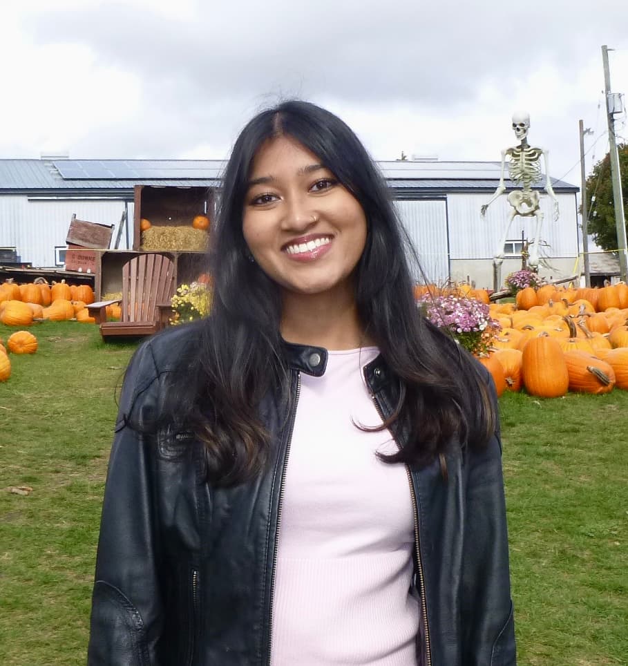 Akanksha Karmakar smiling at a pumpkin patch